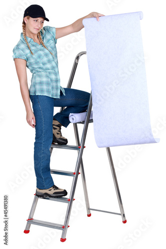 Photo: Women spreading roll of wallpaper Women spreading roll of wallpaper
