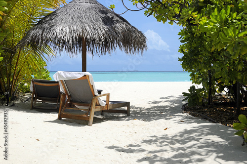 Photo: beach chairs at ocean front under umbrella beach chairs at ocean front under umbrella