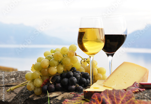 Photo: Two wineglasses, cheese and grapes on the terrace of vineyard in Two wineglasses, cheese and grapes on the terrace of vineyard in