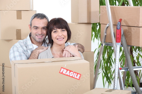 Photo: Couple stood by packed boxes Couple stood by packed boxes