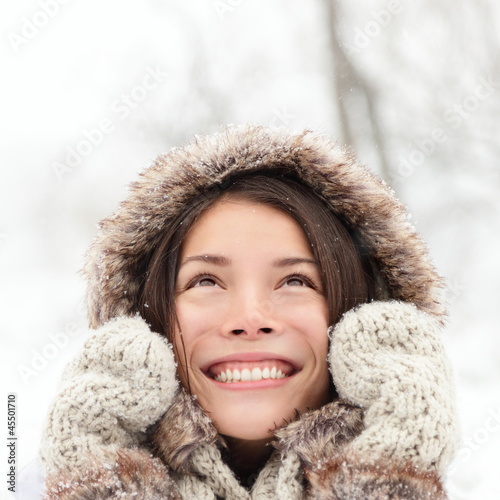 Photo: Winter woman looking up happy and smiling Winter woman looking up happy and smiling