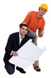 Tradesman standing beside an engineer