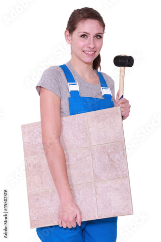 Photo: young woman holding tiles an a hammer young woman holding tiles an a hammer