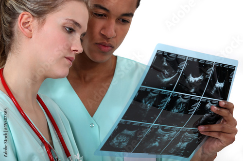 Photo: Two doctors examining a radiography. Two doctors examining a radiography.