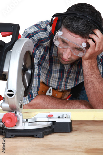 Photo: Man figuring out how to use saw Man figuring out how to use saw
