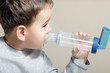 Close-up image little boy using inhaler for asthma.