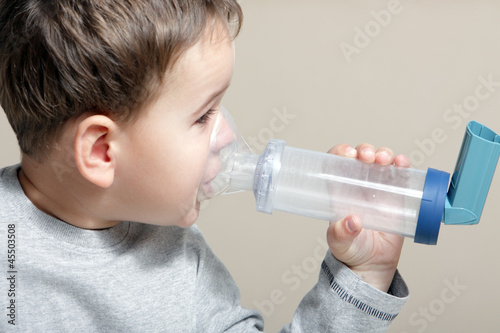 Photo: Close-up image little boy using inhaler for asthma. Close-up image little boy using inhaler for asthma.
