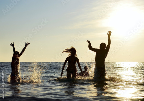 Photo: Silhouettes of people jumping in ocean Silhouettes of people jumping in ocean