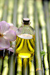 orchids with bottle of massage oil on bamboo background