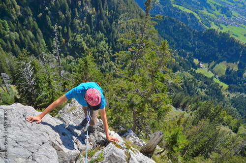 Photo: Junge klettert an Felswand Junge klettert an Felswand