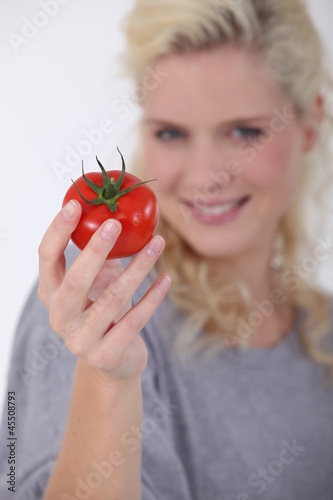 Photo: Woman holding a ripe tomato Woman holding a ripe tomato