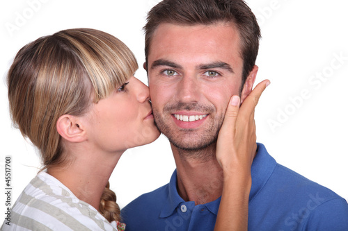 Photo: Young woman kissing a man's cheek Young woman kissing a man's cheek