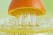 An orange half on a juicer