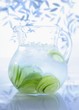 A jug of water with limes