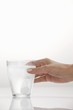 Photo: A hand holding a glass with an effervescent tablet A hand holding a glass with an effervescent tablet