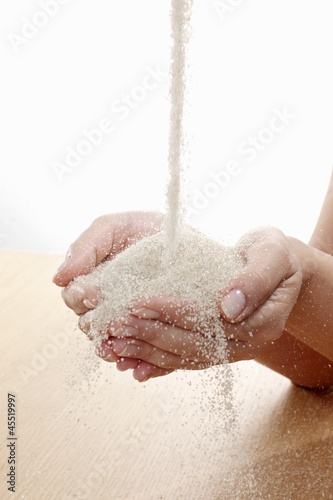 Photo: Raw sugar flowing into hands Raw sugar flowing into hands