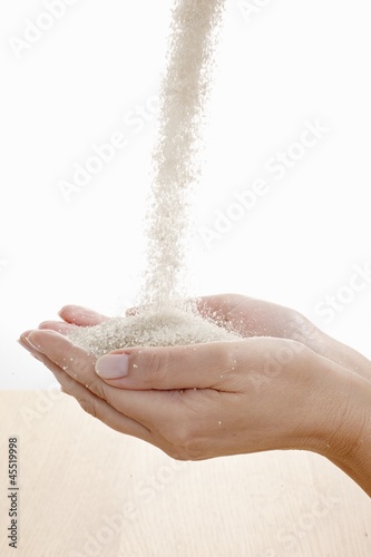 Photo: Raw sugar flowing into hands Raw sugar flowing into hands