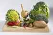 Vegetable still life with mortar and pestle with rose petals on a cutting board