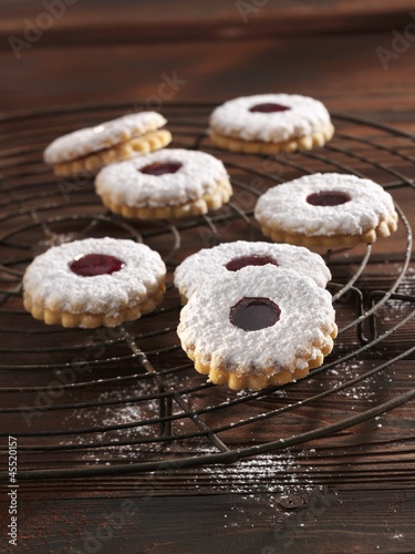 Photo: 'Spitzbuben' (jelly filled cookies) with powdered sugar on a cooling rack 'Spitzbuben' (jelly filled cookies) with powdered sugar on a cooling rack