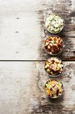 Photo: Barbecue Side Dishes in Small Bowls on a Wooden Table; Pork and Beans, Potato Salad, Cole Slaw and Succotash Barbecue Side Dishes in Small Bowls on a Wooden Table; Pork and Beans, Potato Salad, Cole Slaw and Succotash