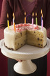 Woman serving birthday cake with burning candles
