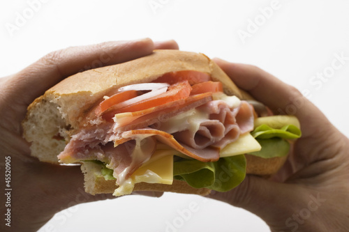 Photo: Hands holding ham and cheese sub sandwich Hands holding ham and cheese sub sandwich