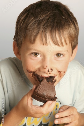 Photo: Boy eating a piece of chocolate cake Boy eating a piece of chocolate cake