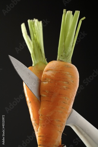 Photo: Cutting a carrot in half with a knife Cutting a carrot in half with a knife