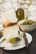 Cheese, olives and olive oil on table out of doors