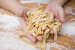 Child's hands holding home-made ribbon pasta