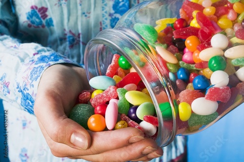 Photo: Person tipping sweets out of jar Person tipping sweets out of jar