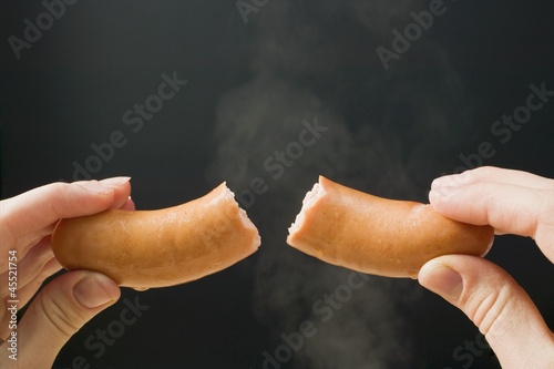 Photo: Hand holding a halved frankfurter Hand holding a halved frankfurter