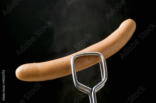 Photo: Tongs holding frankfurter Tongs holding frankfurter