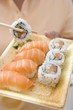 Foto: Woman holding sushi on plastic tray Woman holding sushi on plastic tray