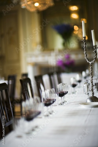 Photo: Table laid in white with glasses of red wine Table laid in white with glasses of red wine