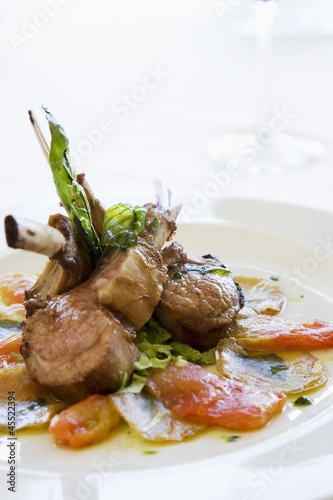 Photo: Lamb chops on tomatoes and potatoes with basil Lamb chops on tomatoes and potatoes with basil