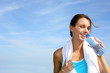 Thirsty fitness girl holding bottle of water