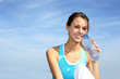 Thirsty fitness girl holding bottle of water
