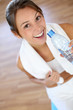 Cheerful fitness girl drinking water after exercising