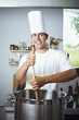 Laughing chef stirring pan