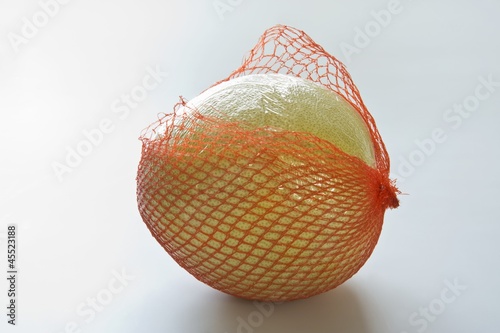 Photo: Pomelo in torn net Pomelo in torn net