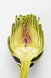 Half an artichoke on a white surface