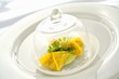 Ravioli filled with king crab under a glass cloche on a glass plate