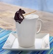 Steamed Milk in a White Mug with a Pear Shaped Chocolate Stick