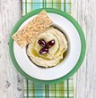 Hummus with Olive Oil and Olives in a Bowl with Sesame Seed Flat Bread