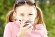 A girl eating a chocolate marshmallow