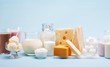 Various milk products (cheese, ice cream, milkshakes and milk) on a blue background