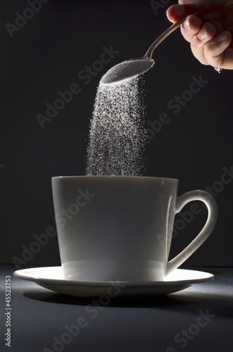 Photo: Pouring Spoonful of Sugar into a Coffee Mug Pouring Spoonful of Sugar into a Coffee Mug