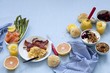 A breakfast table laid with scrambled egg, salmon, jam, muesli and grapefruit