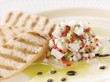 Citrus Ceviche of Bass Fish with Grilled Bread on a White Plate